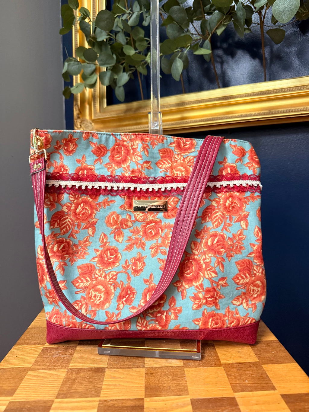 Back of tote with red lace trim and The Seam Queens label