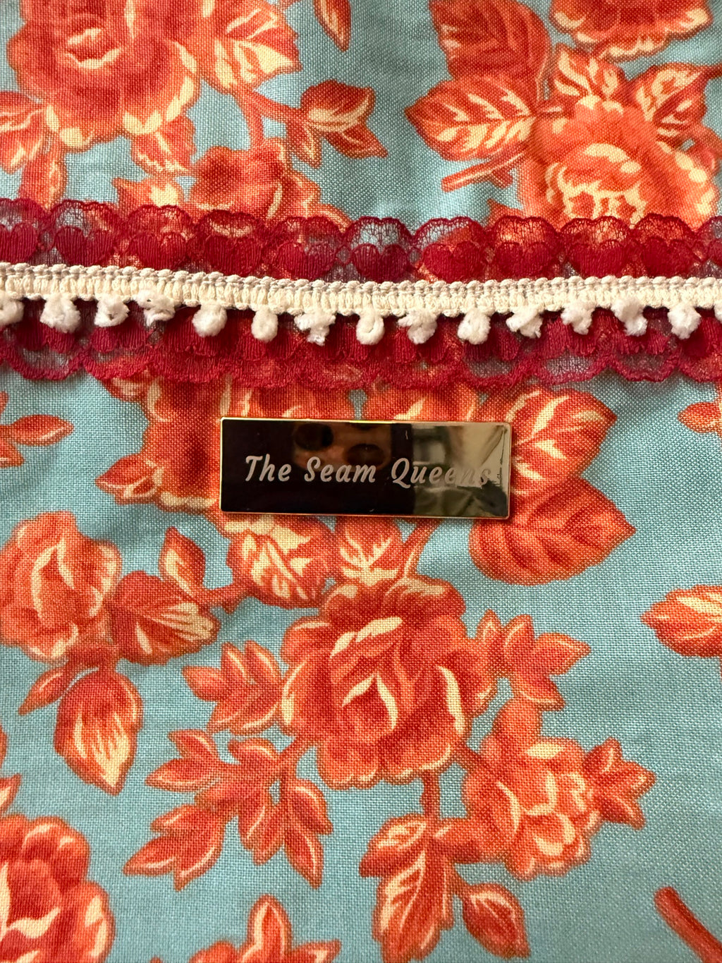 The Seam Queens gold label and lace trim, close-up