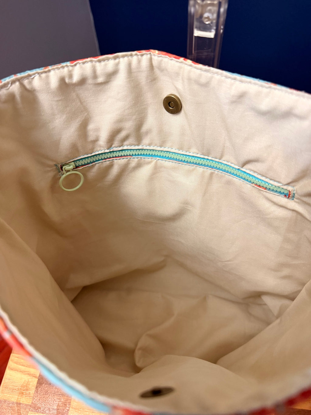 Cream lining with interior zipper pocket and magnetic snap closure