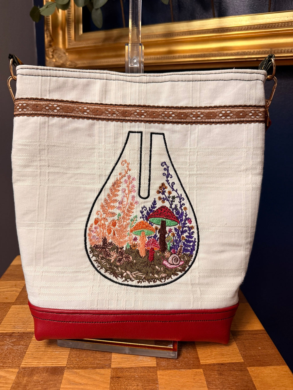 Front of the tote with red vinyl strap and bottom