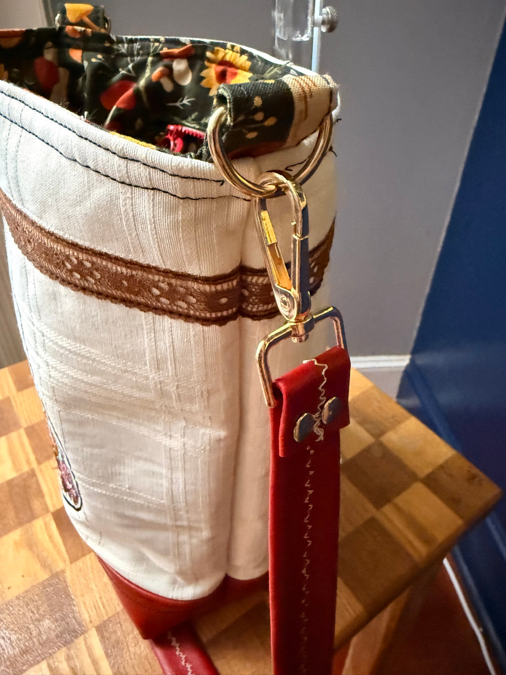 Gold D-ring and clasp with red vinyl strap, close-up