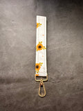 Keychain wristlet in white sunflower fabric with gold hardware